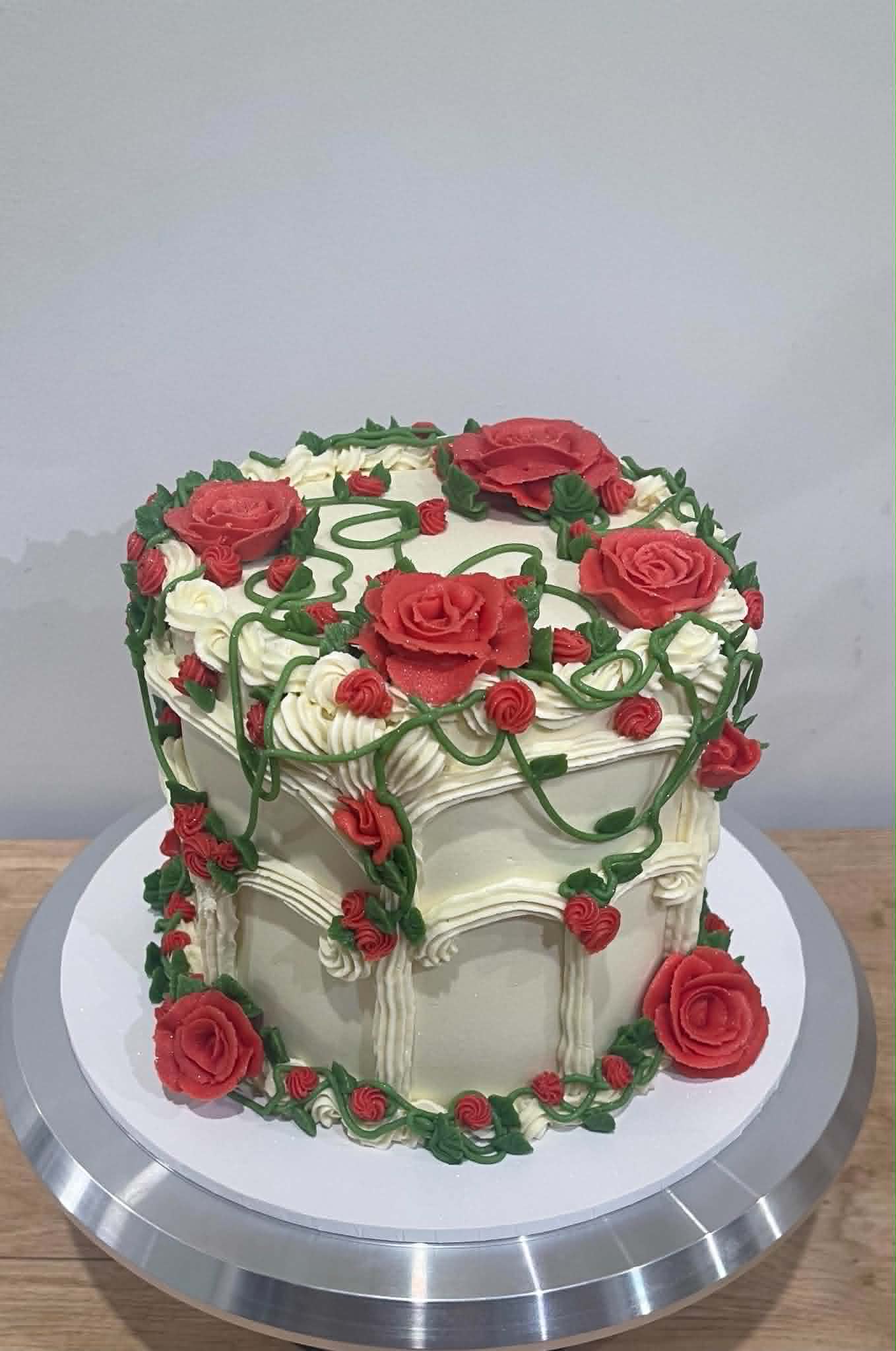 Vintage buttercream cake with red piped roses and green vines